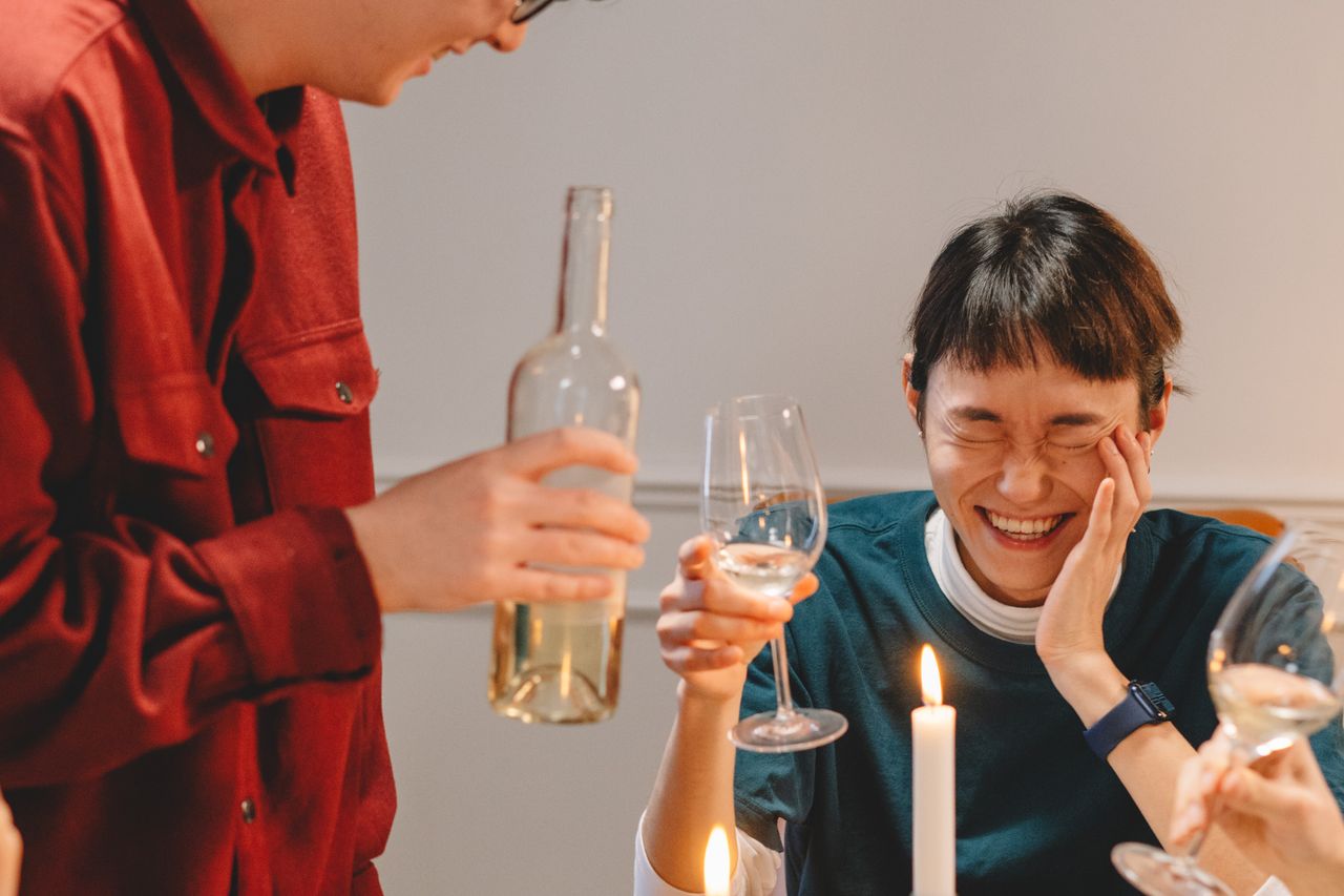 Group of friends laughing at a dinner party
