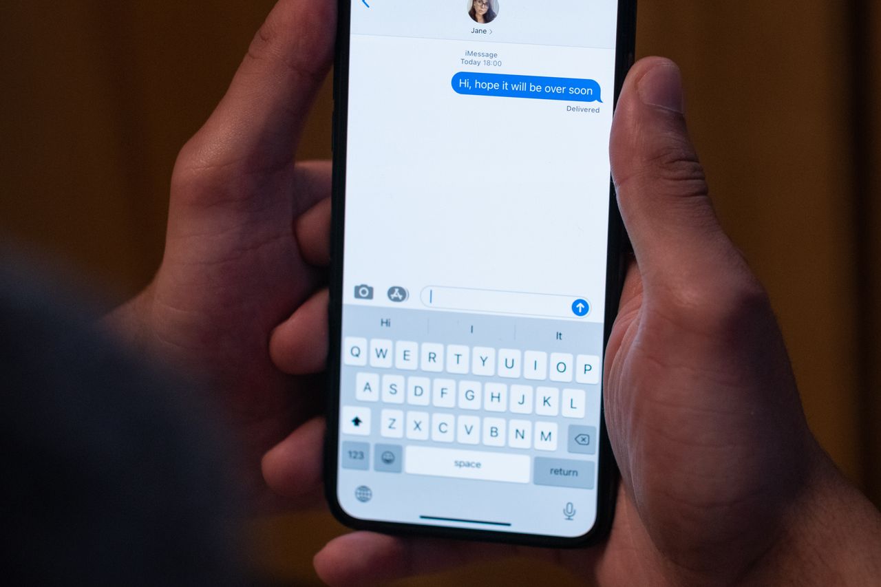 Hand typing a text message on a smartphone