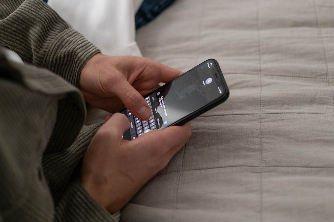 Hands typing a message on a smartphone
