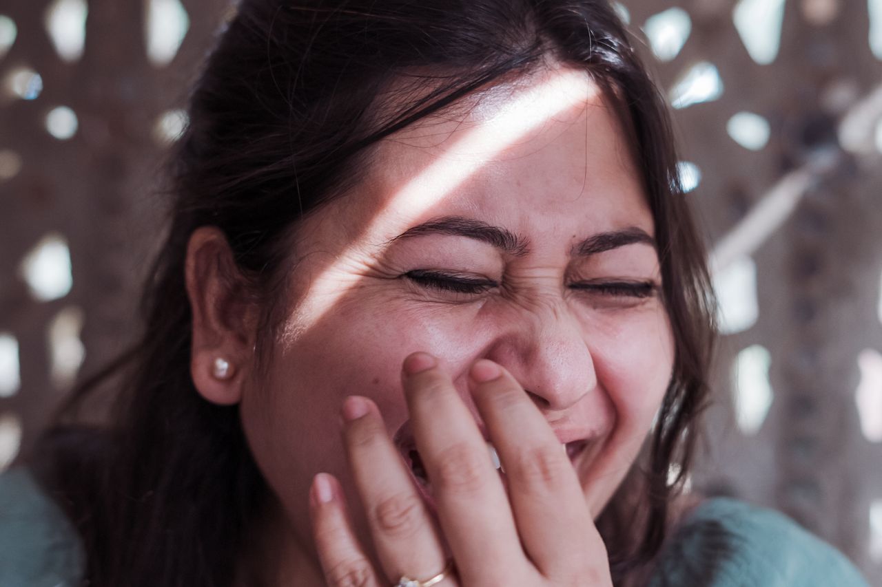 Woman laughing with genuine joy in natural light